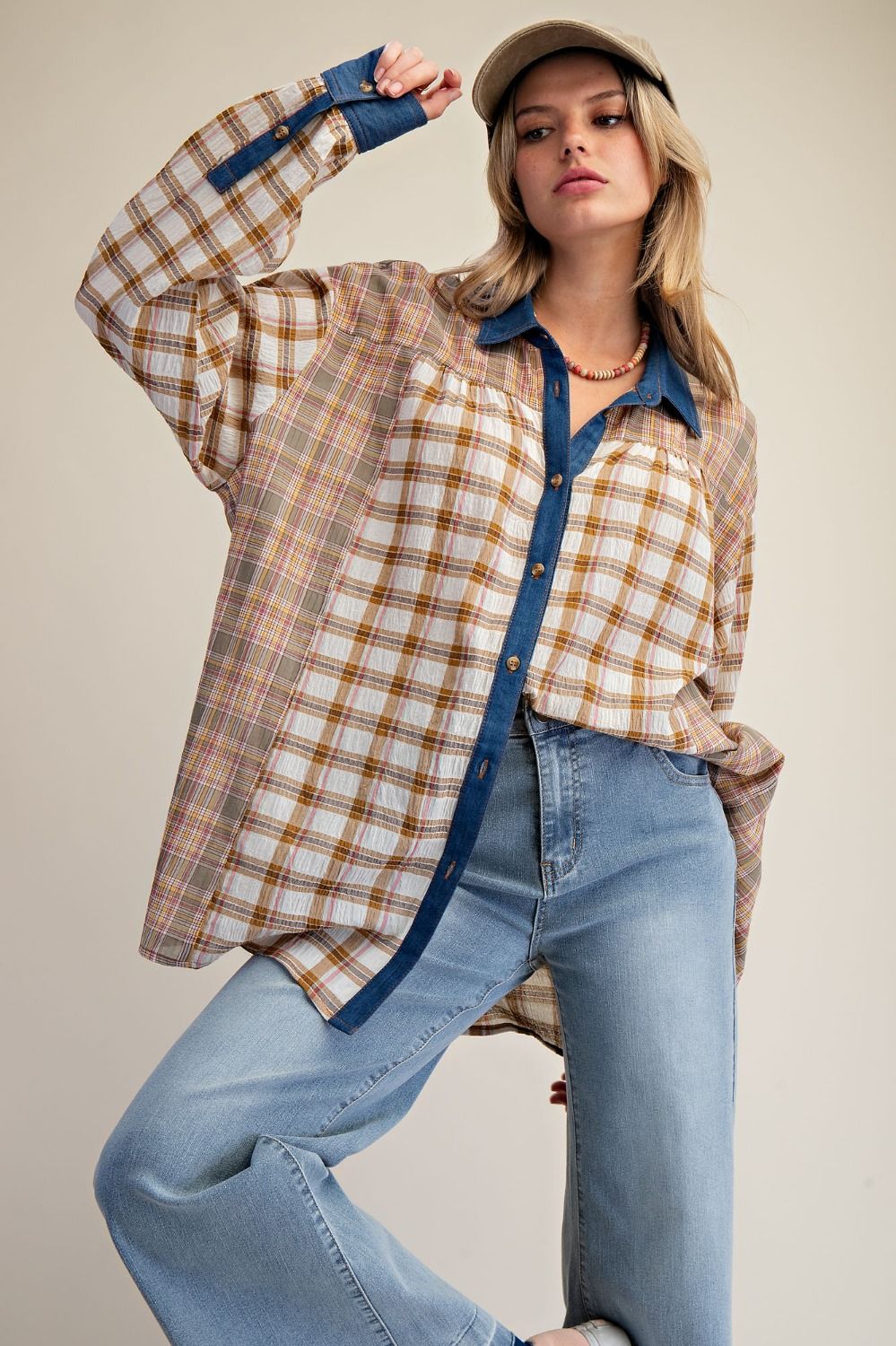 Woman wearing a plaid shirt and jeans with a neutral background