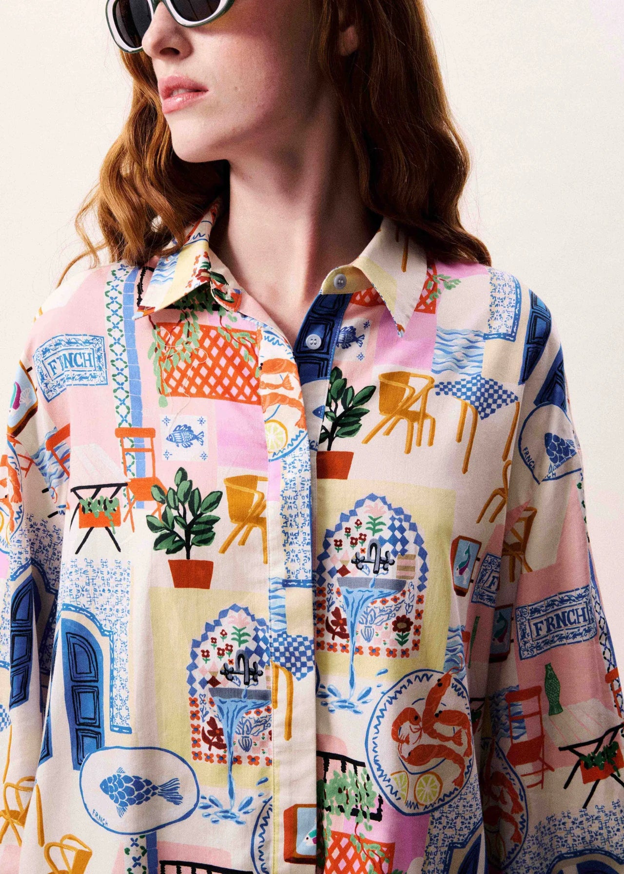 Person wearing a colorful patterned shirt with a neutral background