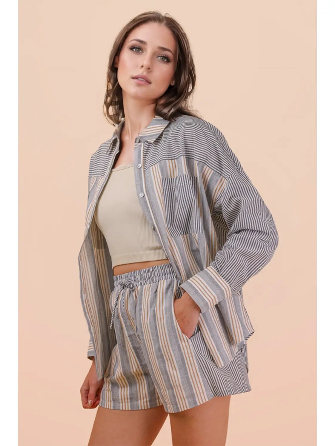Woman wearing a striped shirt and shorts on a beige background