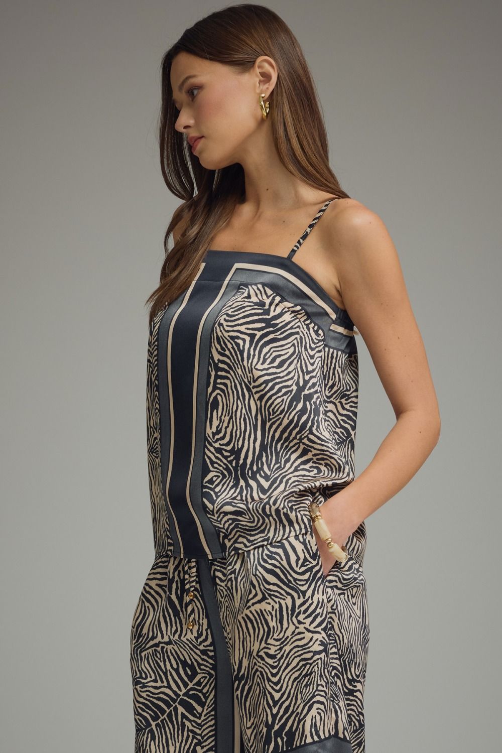 Woman wearing a patterned dress against a gray background