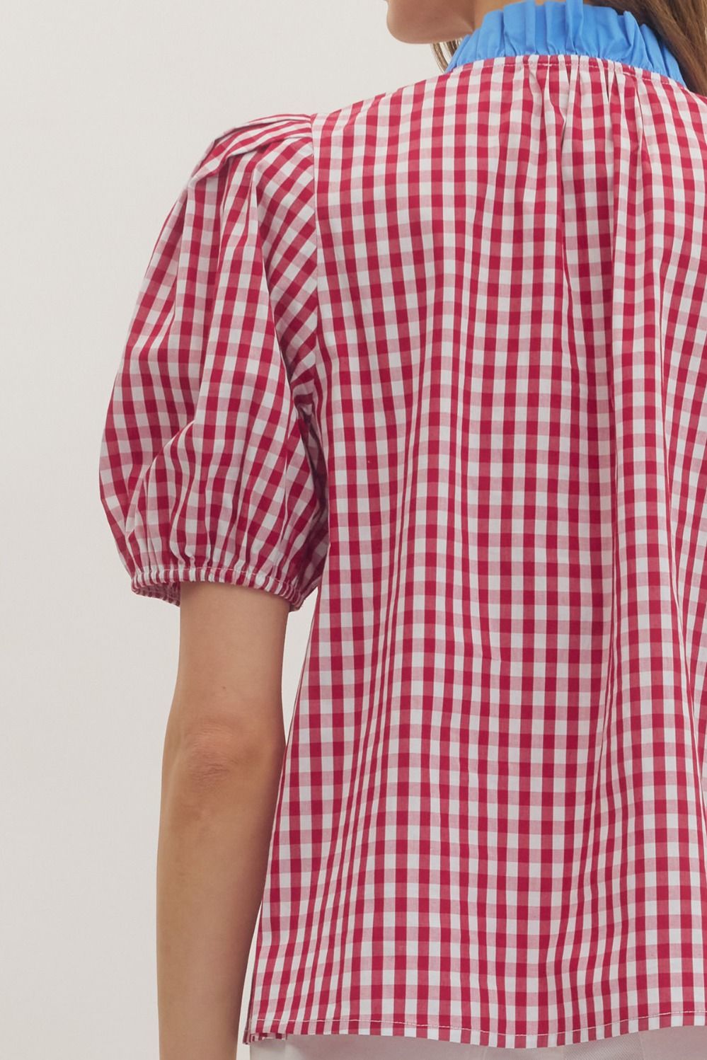 Red and white checkered blouse with puff sleeves on a plain background