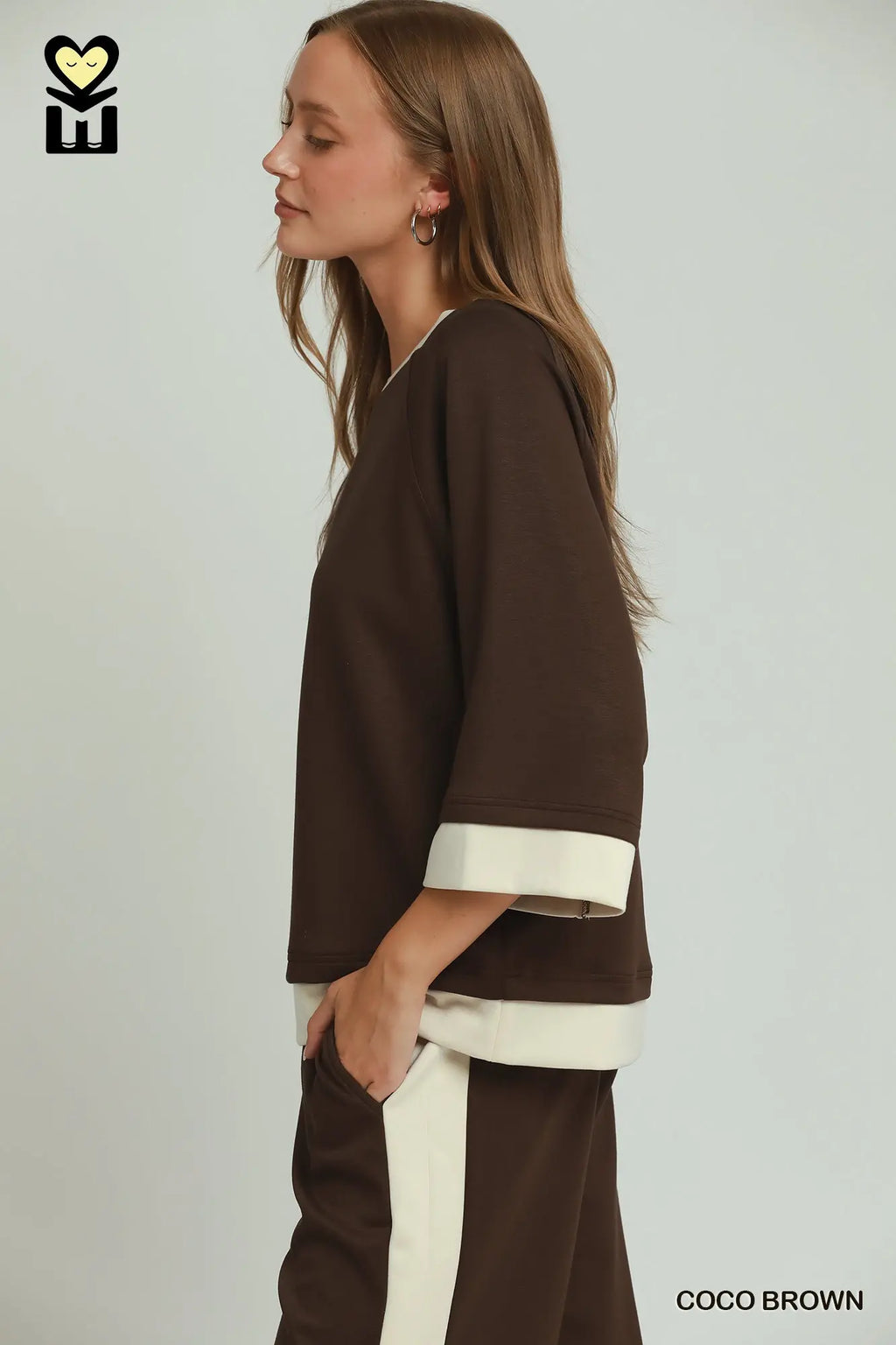 Woman wearing a brown and white outfit with a plain background