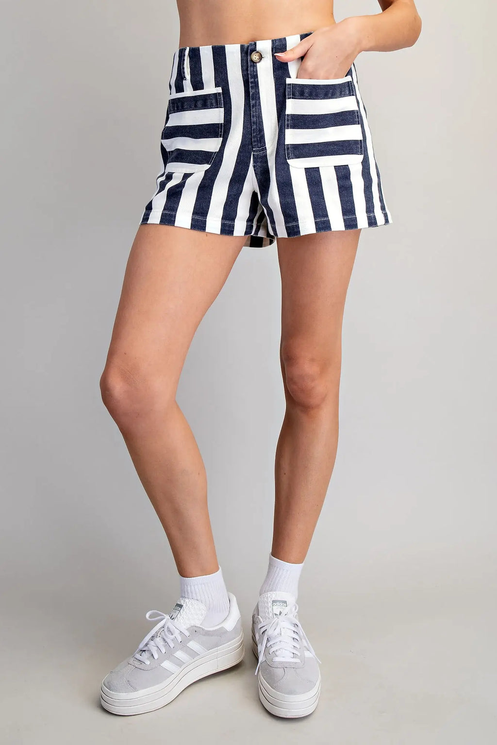 Person wearing navy and white striped shorts on a plain background