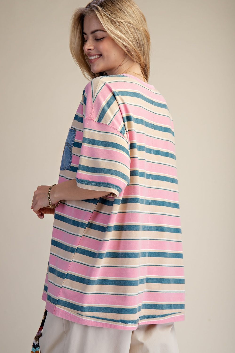 Woman wearing a colorful striped shirt against a beige background