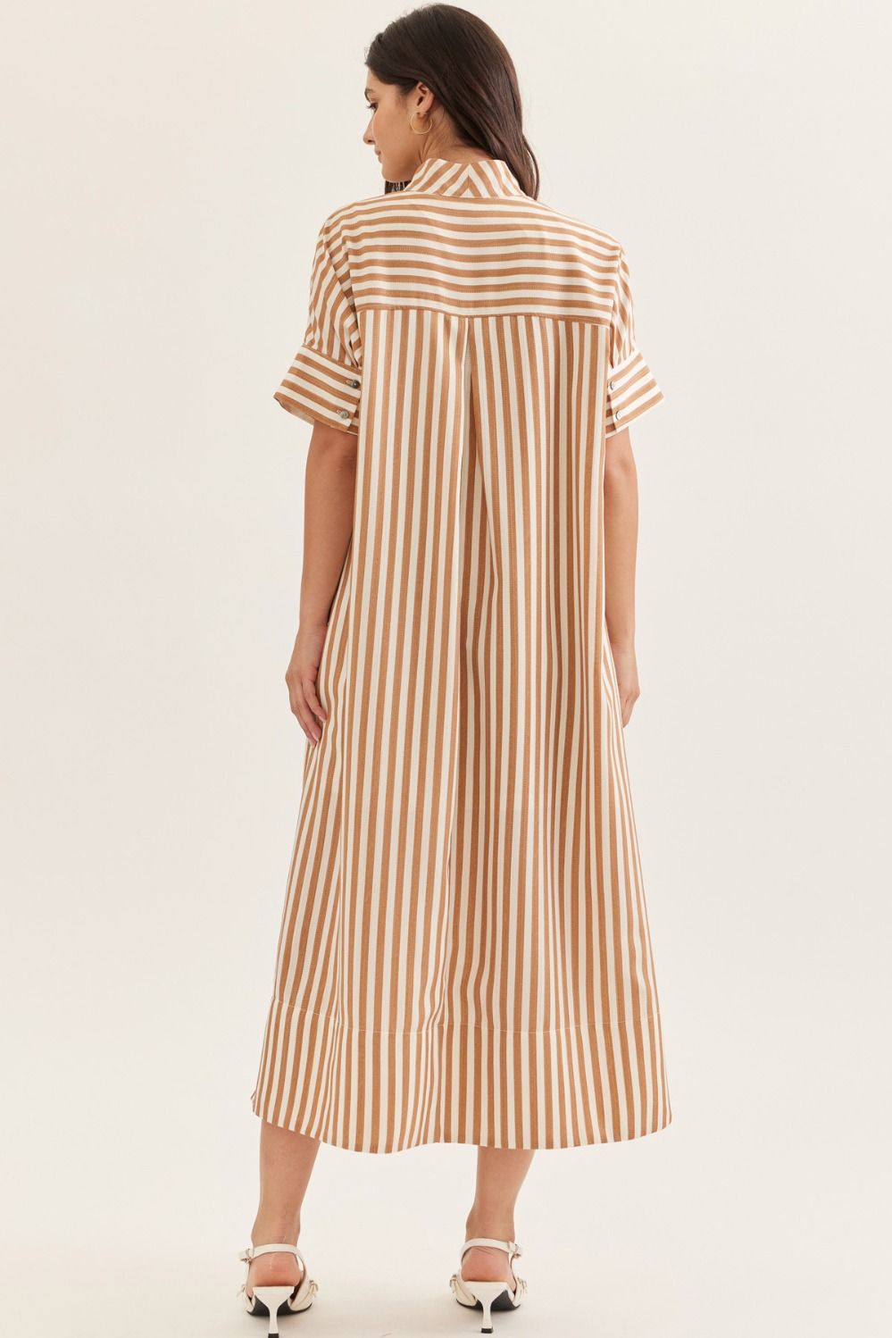 Woman wearing a striped dress on a plain background