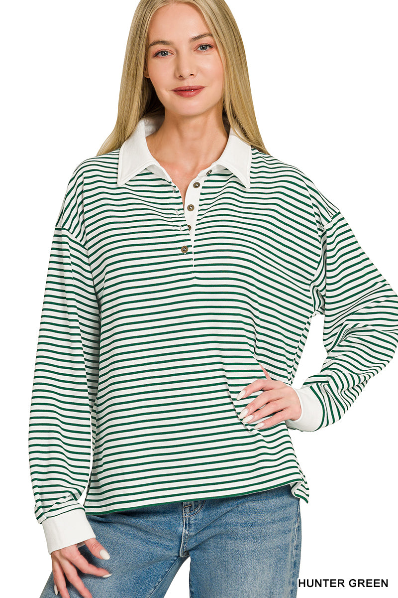 A woman modeling a long-sleeve collared polo shirt with horizontal green and white stripes, paired with blue jeans, against a plain white background.