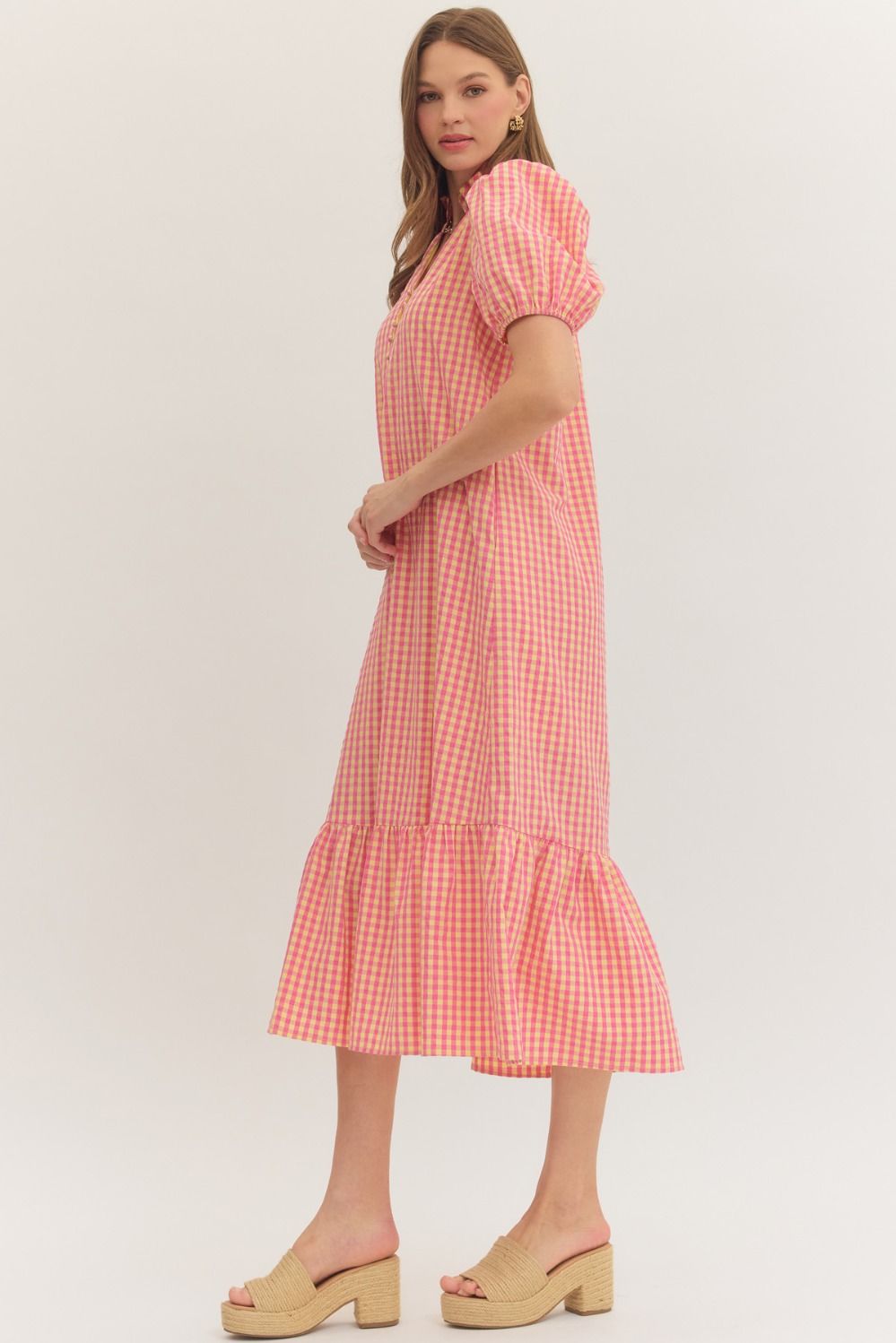 Woman wearing a pink checkered dress on a white background