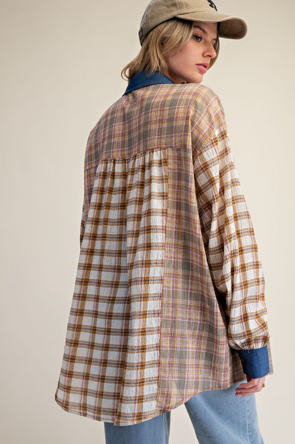 Person wearing a plaid shirt with a neutral background