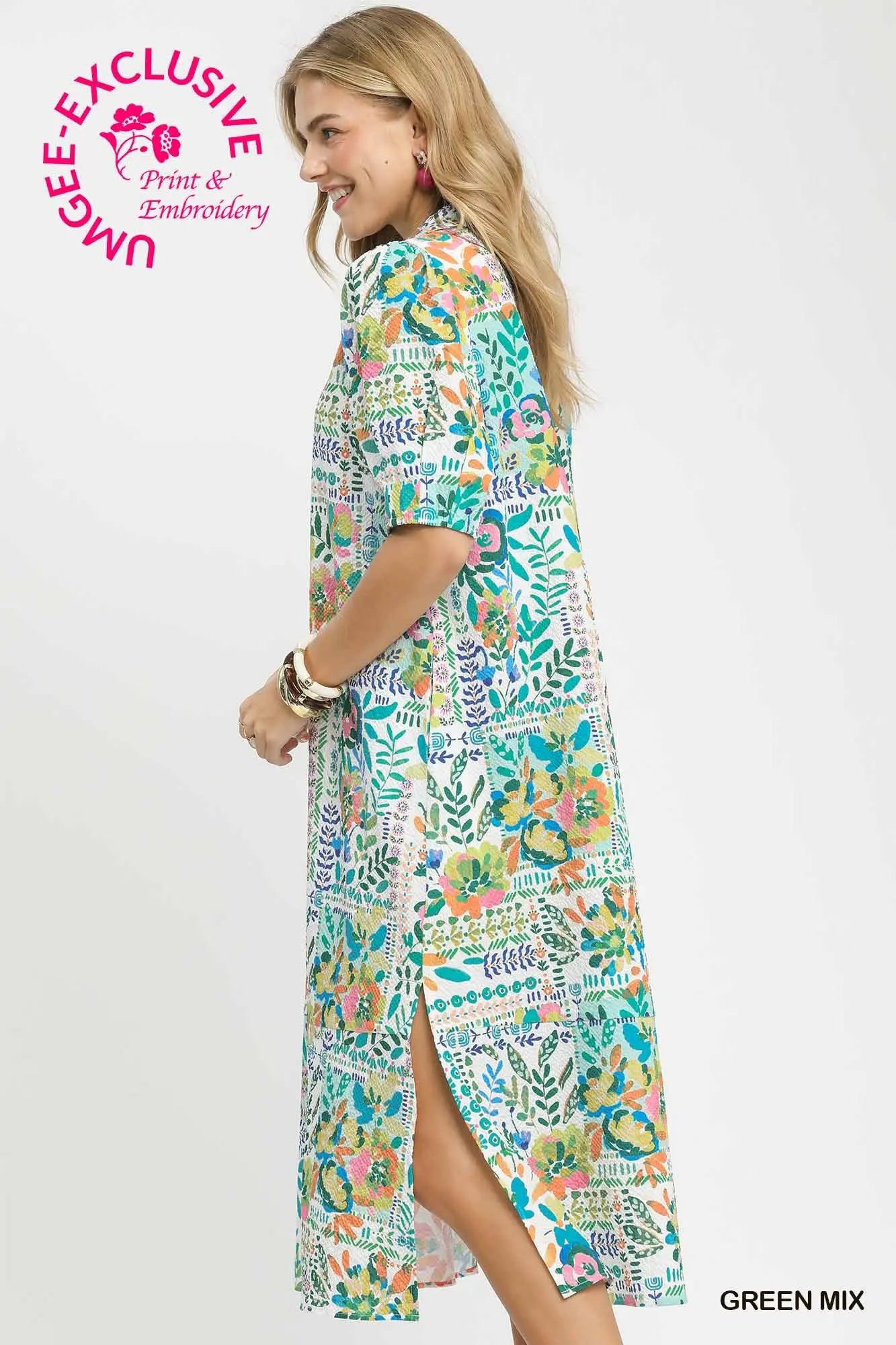 Woman wearing a colorful dress with a pattern, standing against a white background. UMGEE Exclusive branding is visible.
