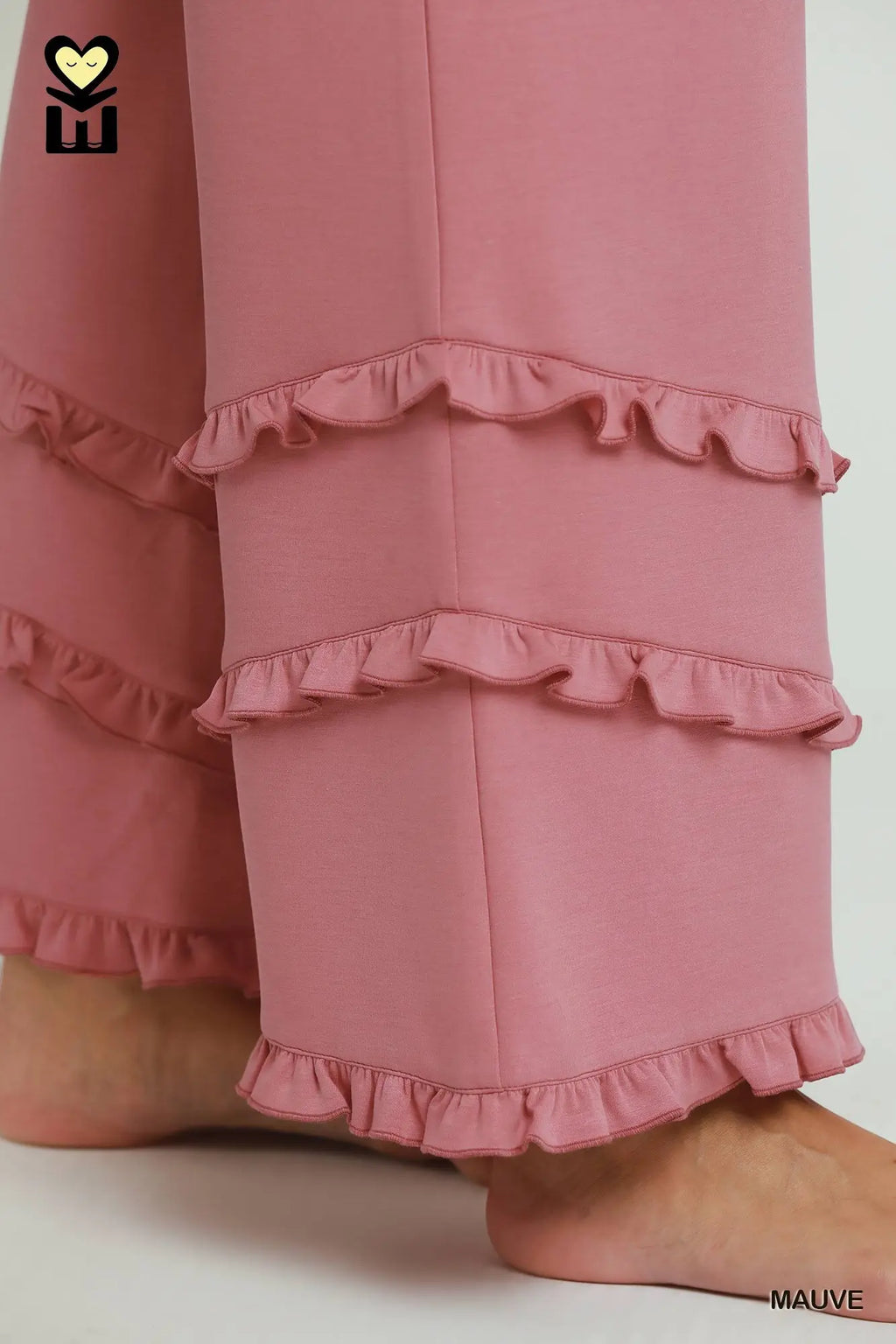 Pink pants with ruffled details on a white background