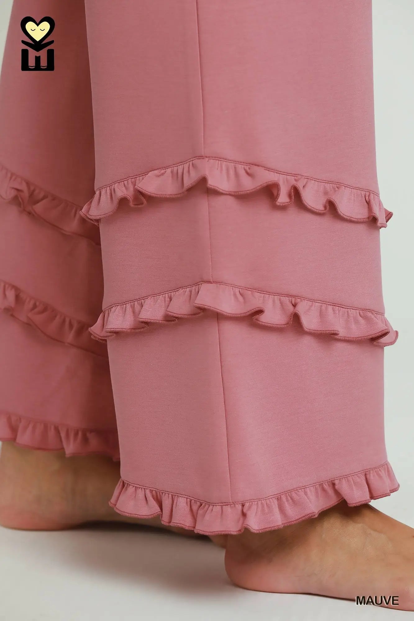 Pink pants with ruffled details on a white background