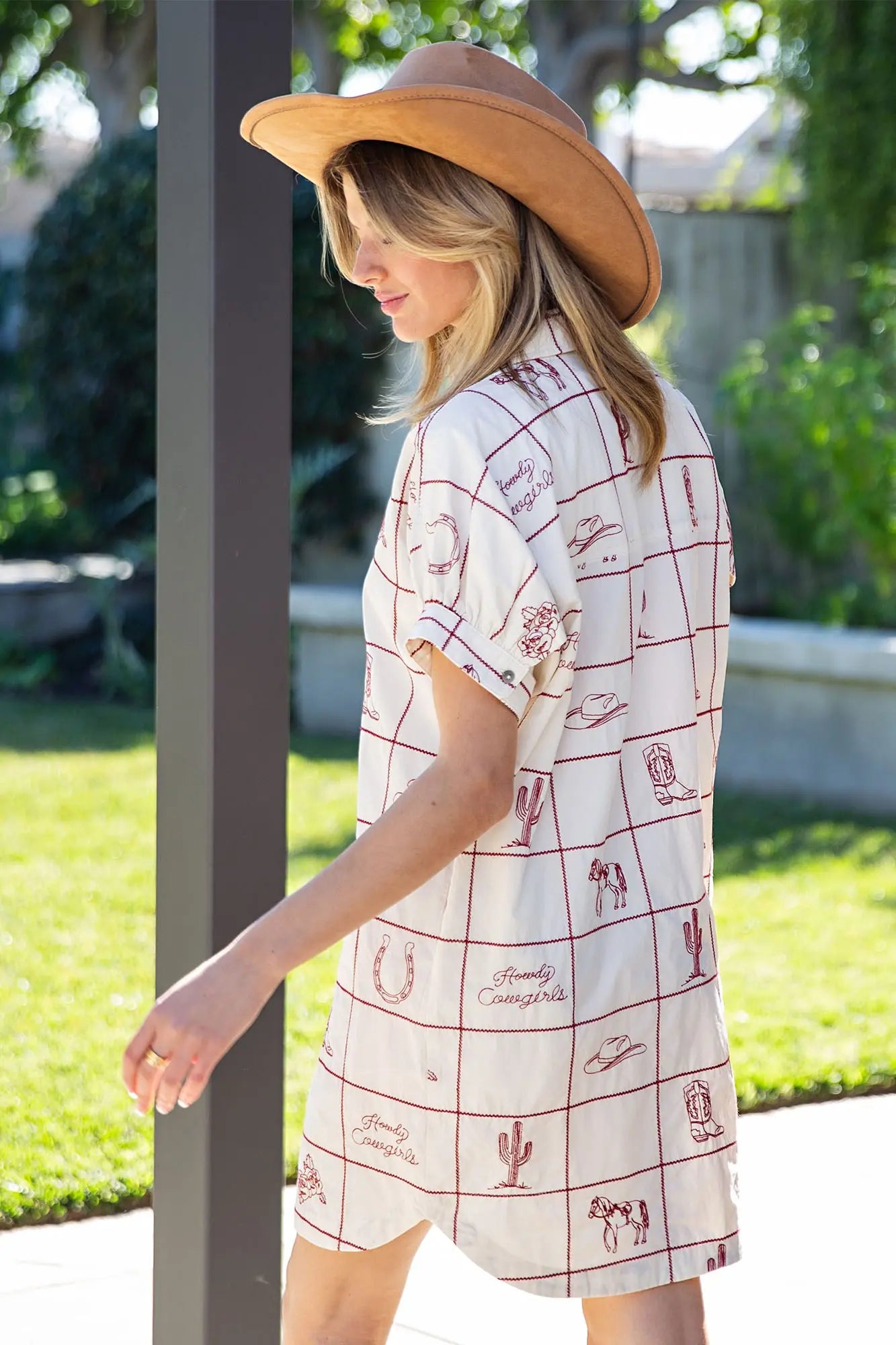 Woman wearing a patterned dress and wide-brimmed hat outdoors