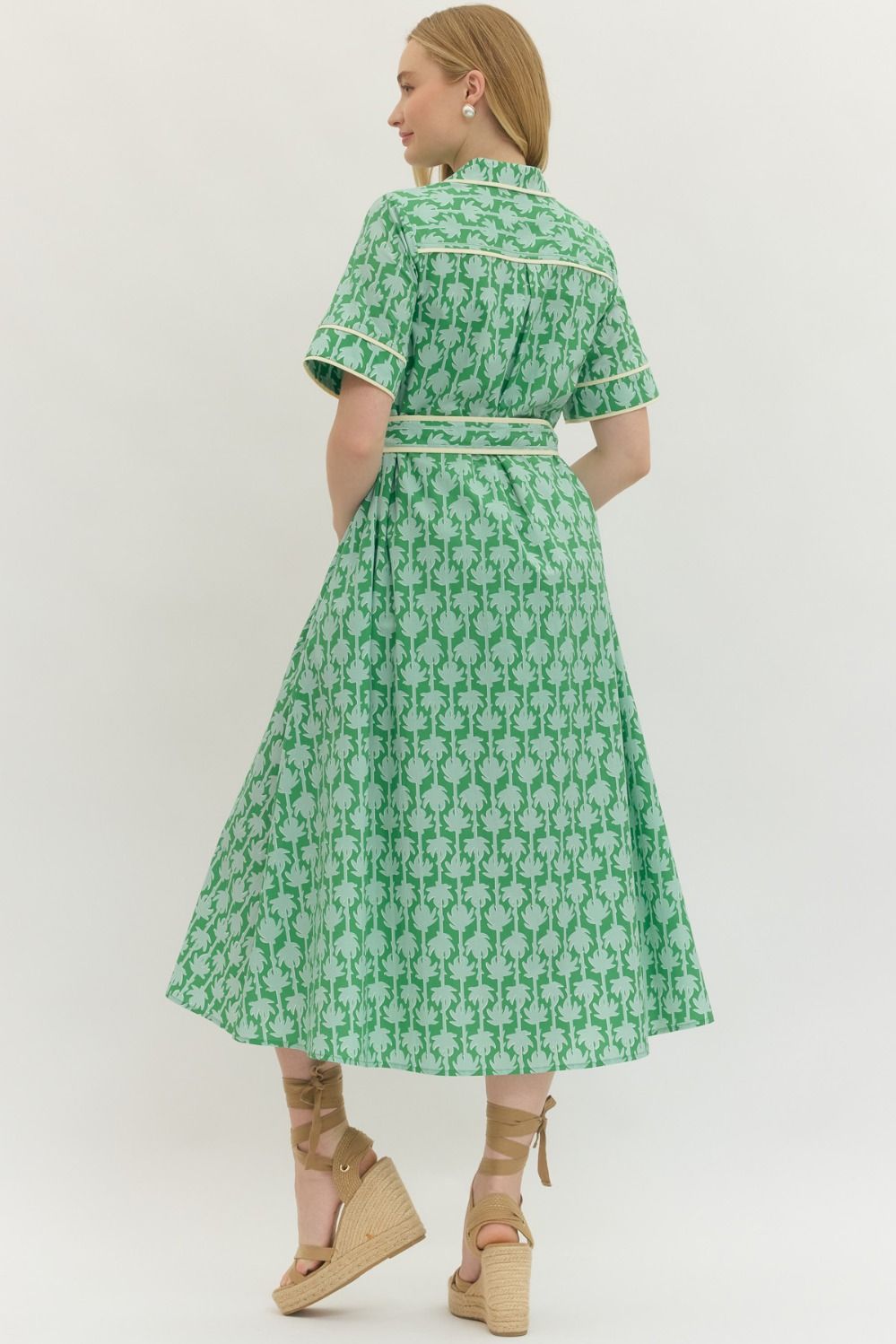 Woman wearing a green patterned dress on a white background