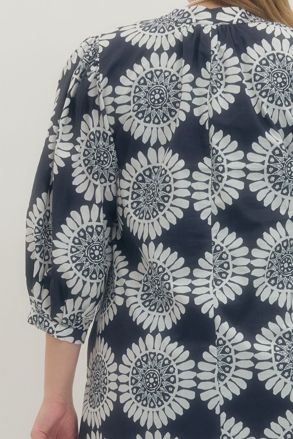 Navy blue dress with white floral pattern worn by a person