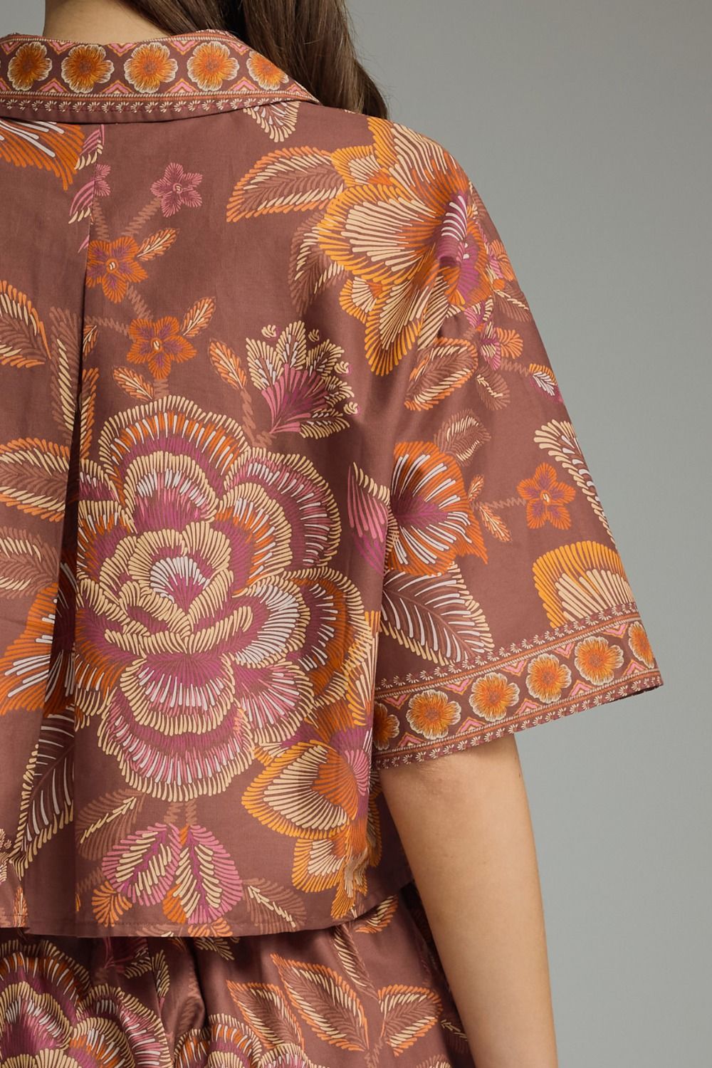 Close-up of a brown floral patterned shirt with a neutral background