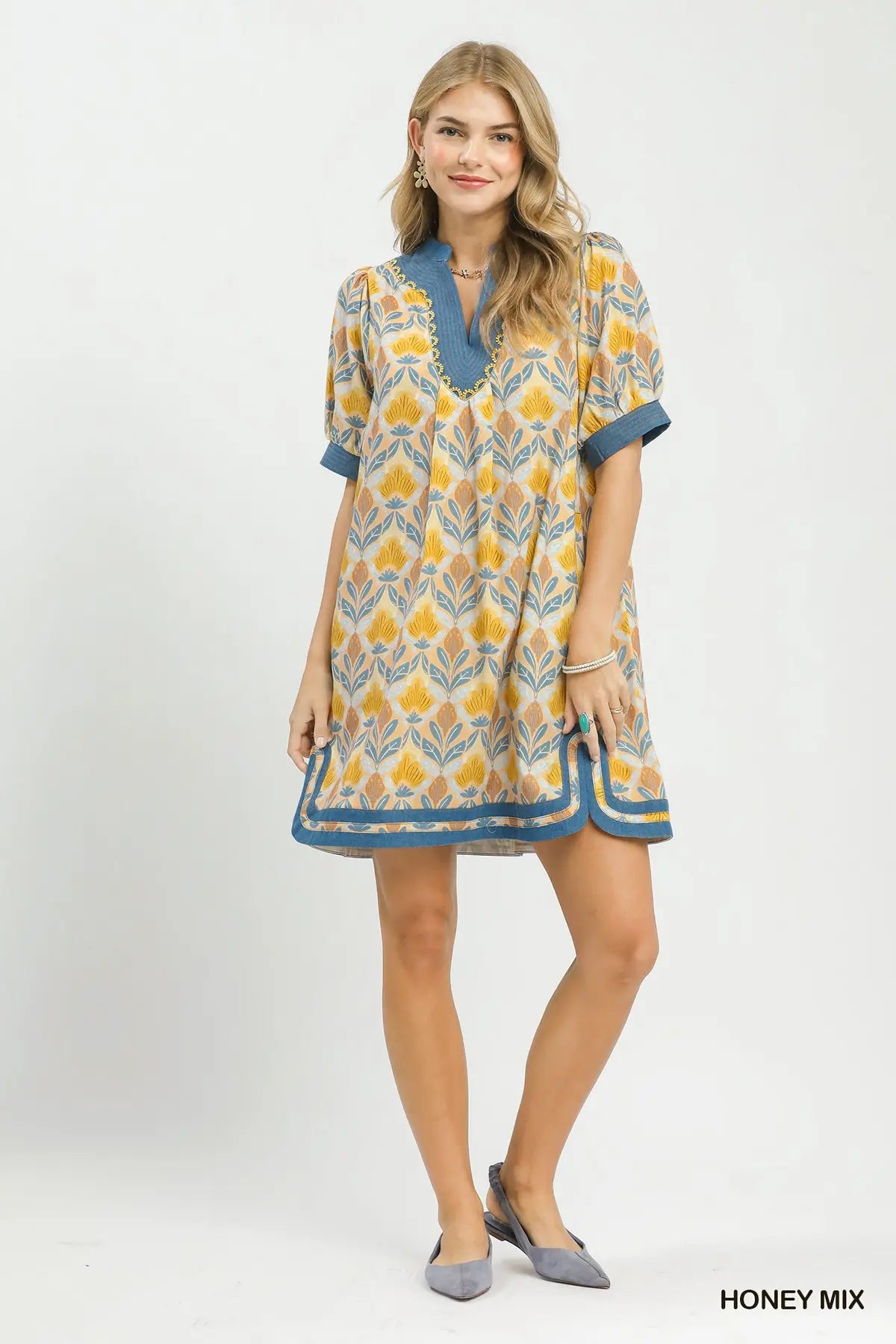 Woman wearing a patterned dress with a white background