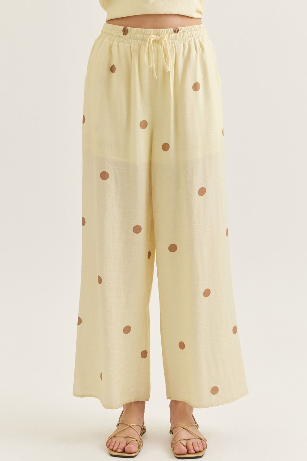 Light yellow pants with brown polka dots on a white background