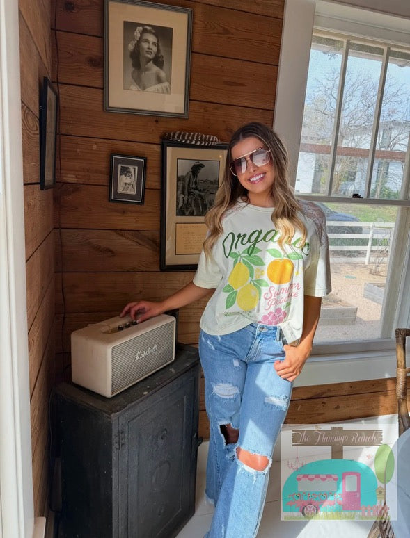Woman in a casual setting wearing a graphic t-shirt and jeans, standing next to a radio.
