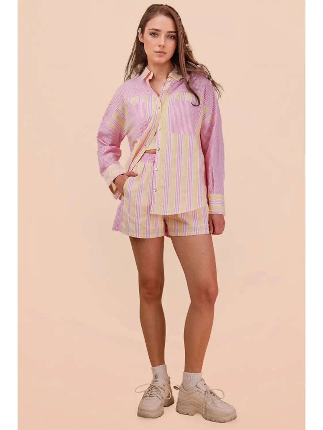 Woman wearing a pink and white striped outfit on a beige background