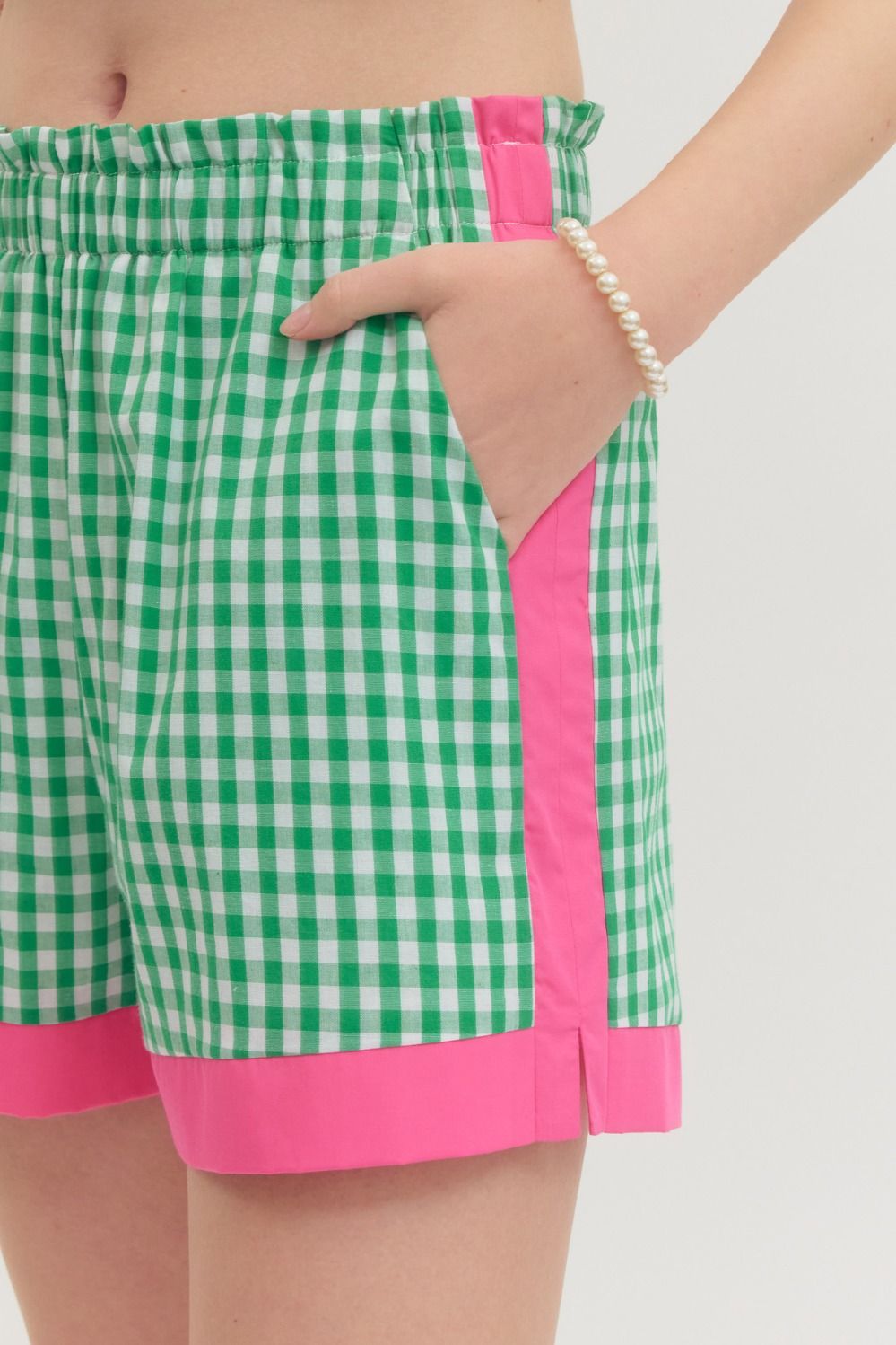 Green and pink checkered shorts on a plain background