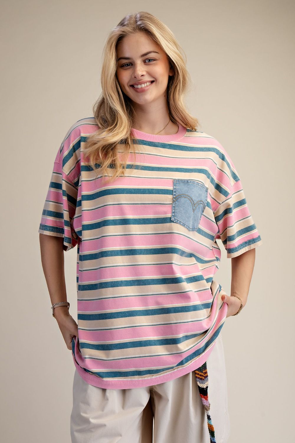 Woman wearing a striped shirt with a pocket on a beige background