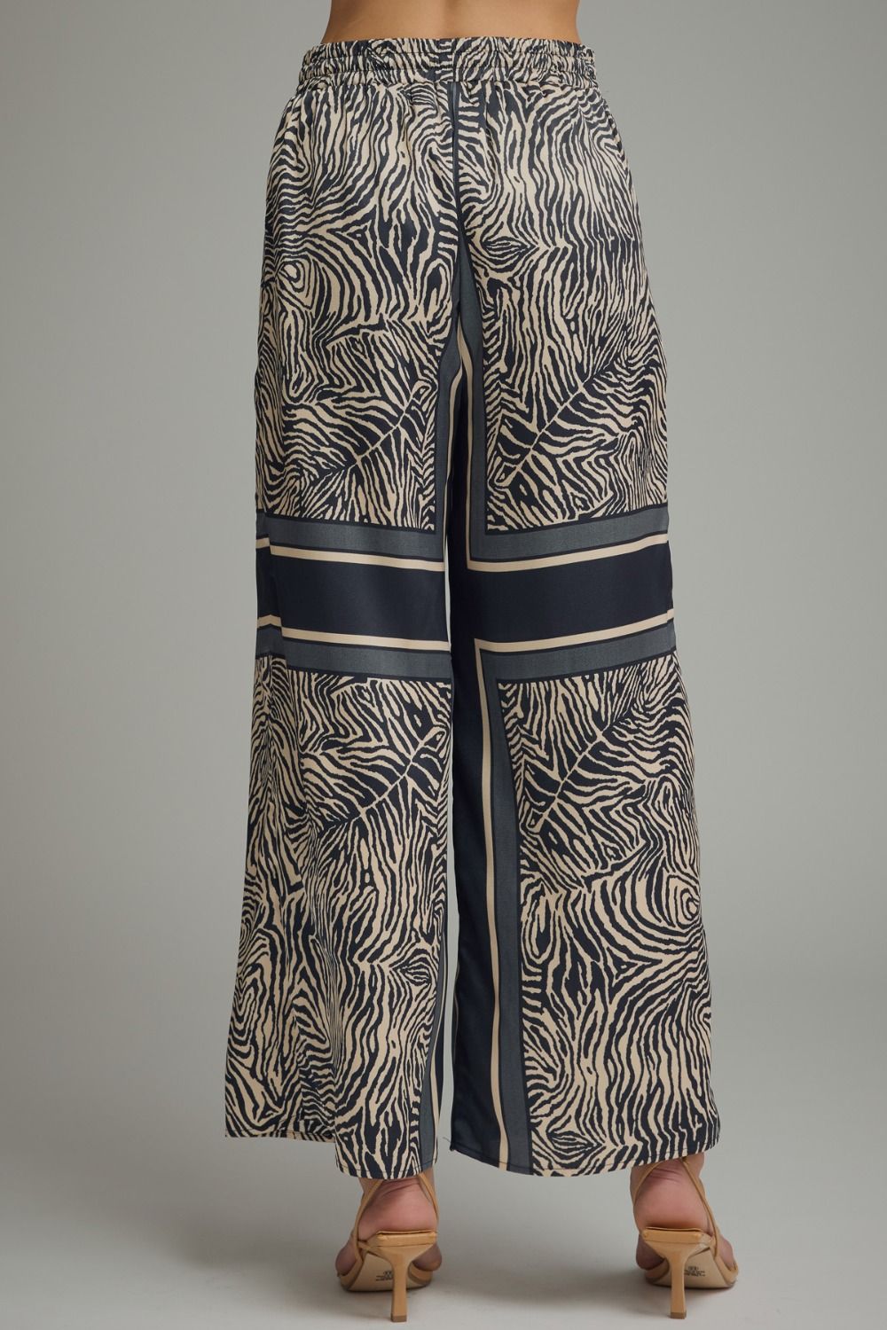 Zebra print pants with blue and beige accents on a gray background