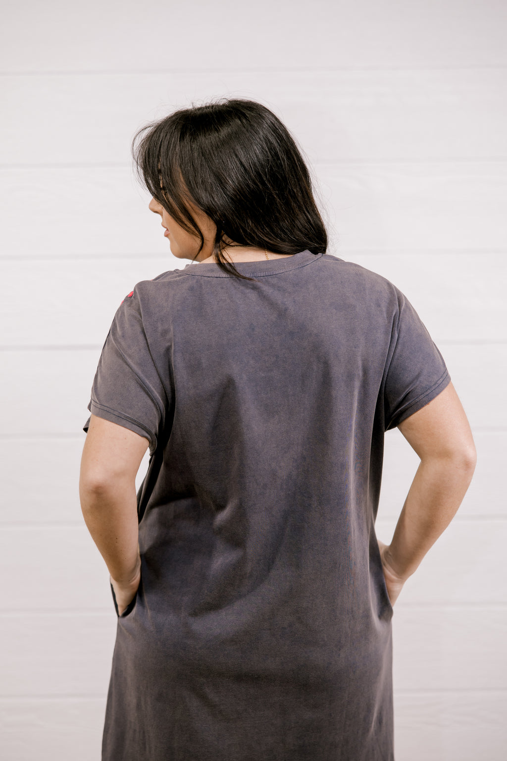Person wearing a gray t-shirt against a white background