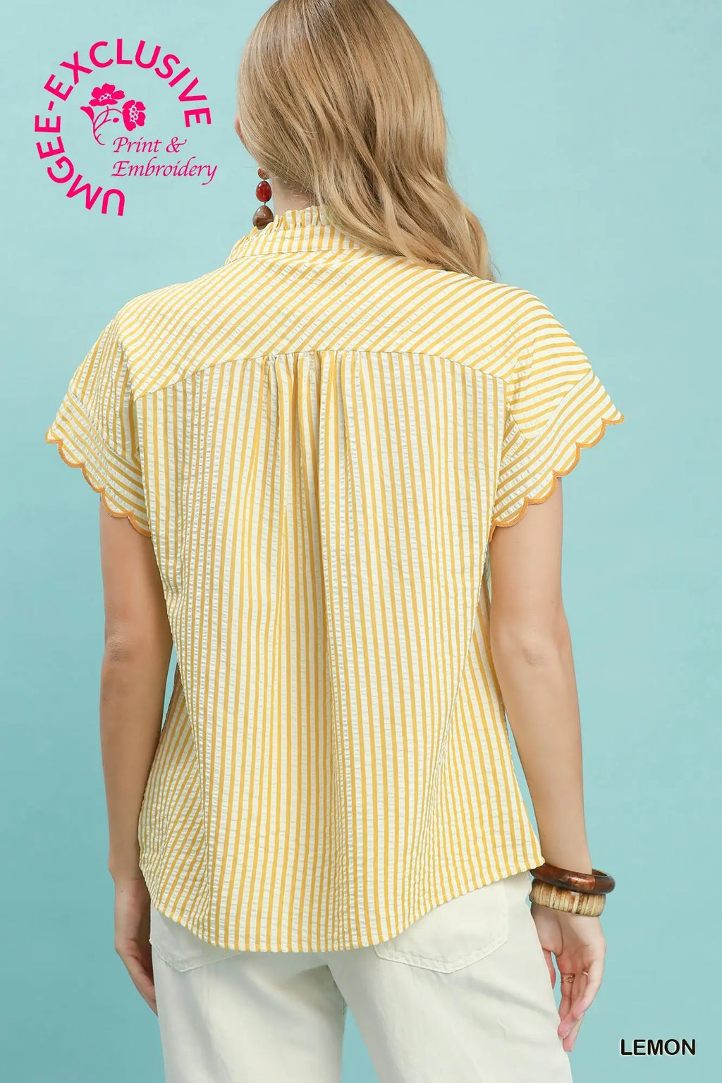 Woman wearing a yellow striped shirt against a light blue background