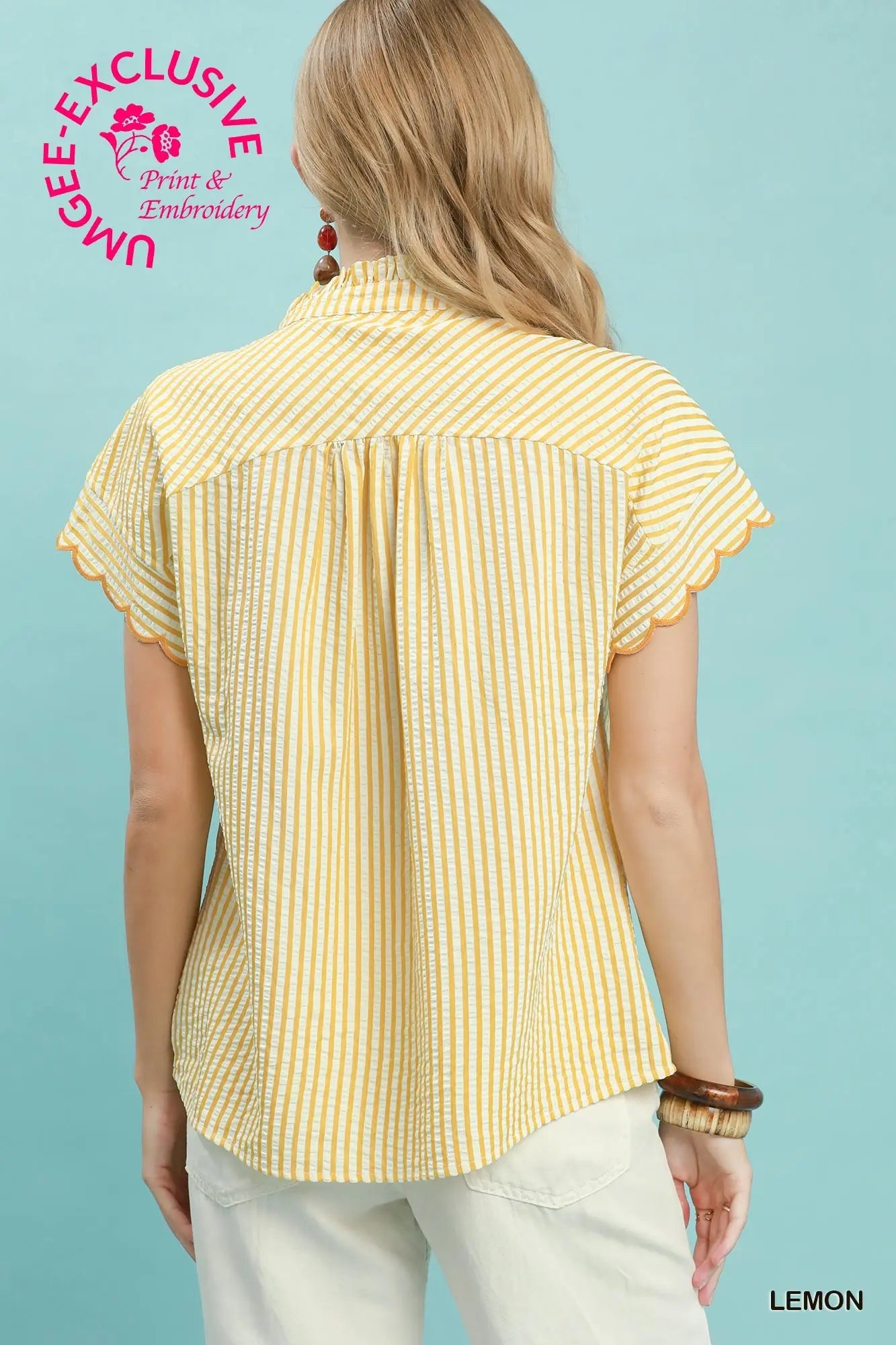 Woman wearing a yellow striped shirt against a light blue background