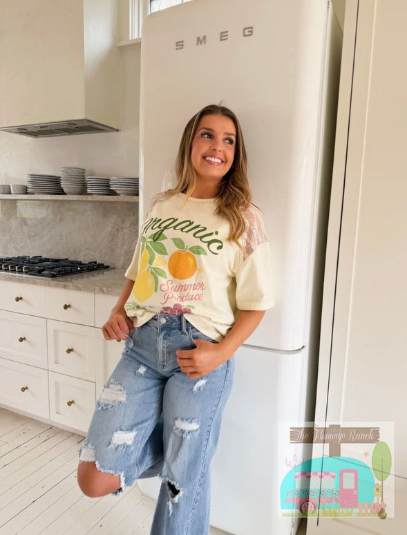 Woman in a kitchen wearing a 'Summer Yuzu' t-shirt standing next to a Smeg refrigerator.