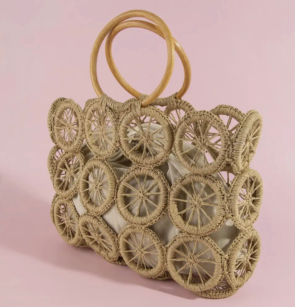Woven handbag with circular patterns on a pink background