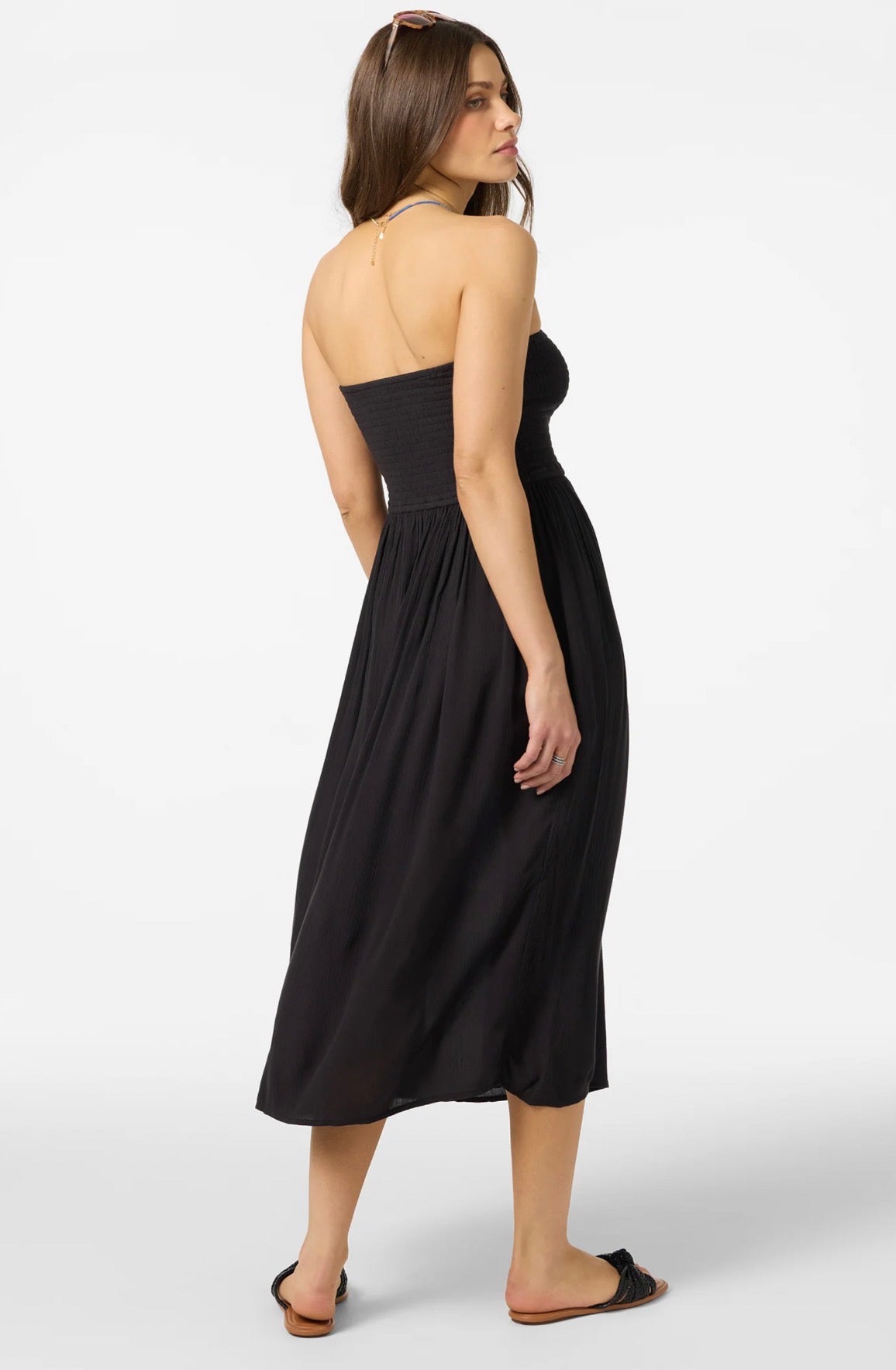 Woman wearing a black strapless dress on a white background