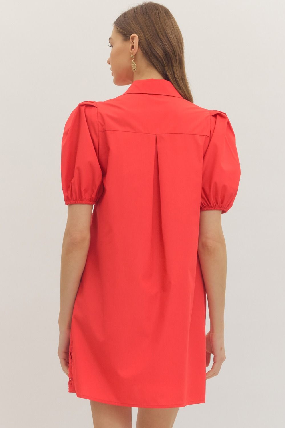 Red dress with puff sleeves worn by a person on a light gray background