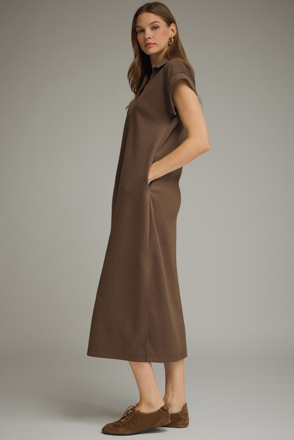 Woman wearing a brown dress against a neutral background