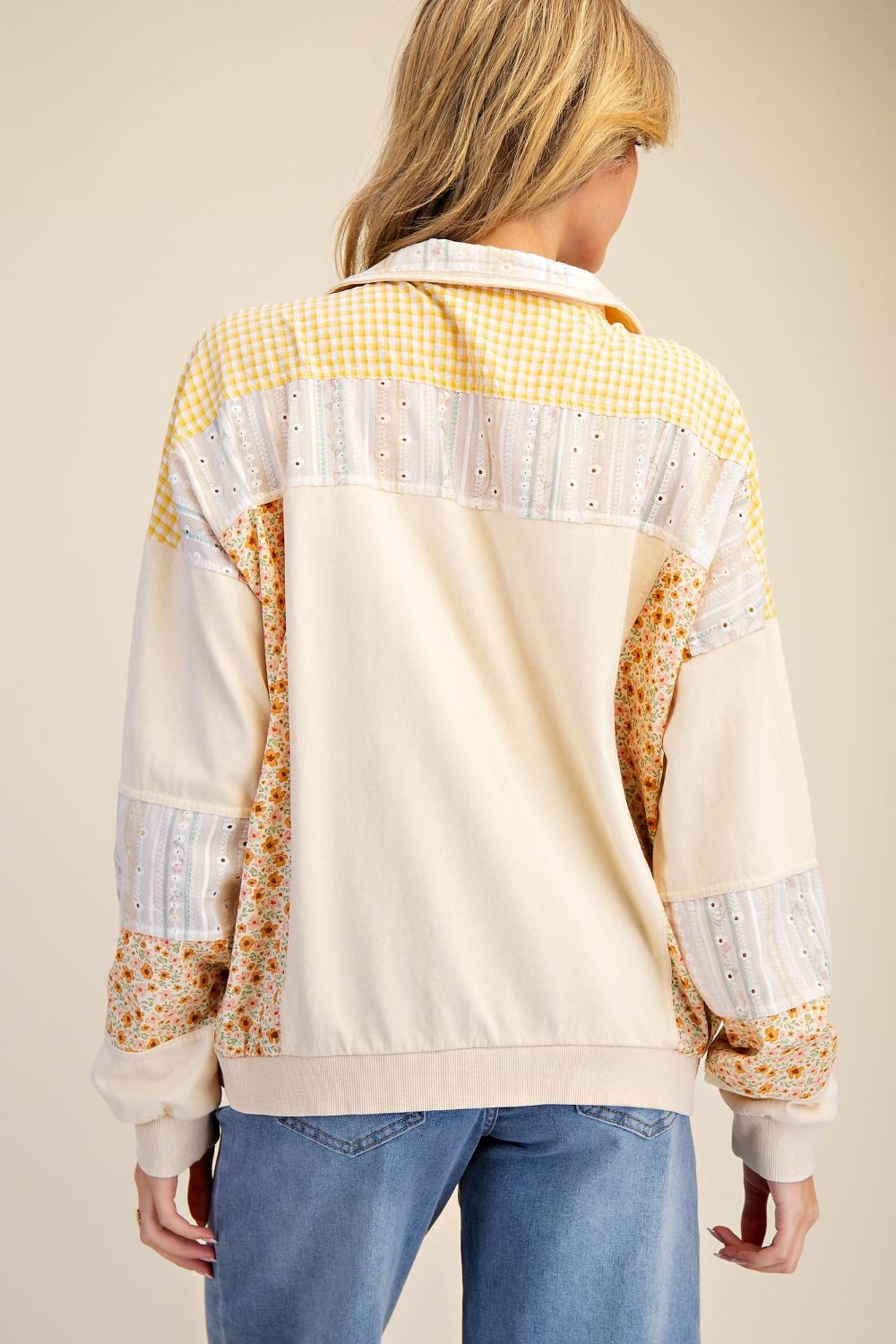 Person wearing a colorful jacket with a checkered pattern on a beige background