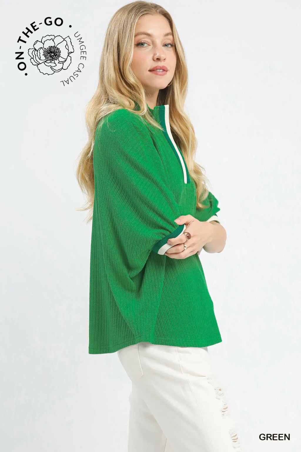 Woman wearing a green sweater with 'On-The-Go' branding on a white background