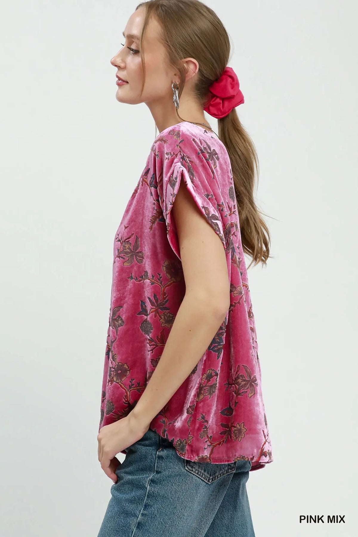Woman wearing a pink floral blouse with a white background