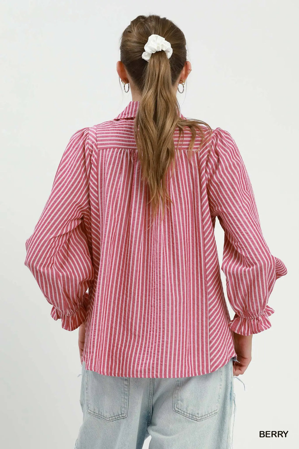 Person wearing a red and white striped shirt with puffed sleeves on a plain background