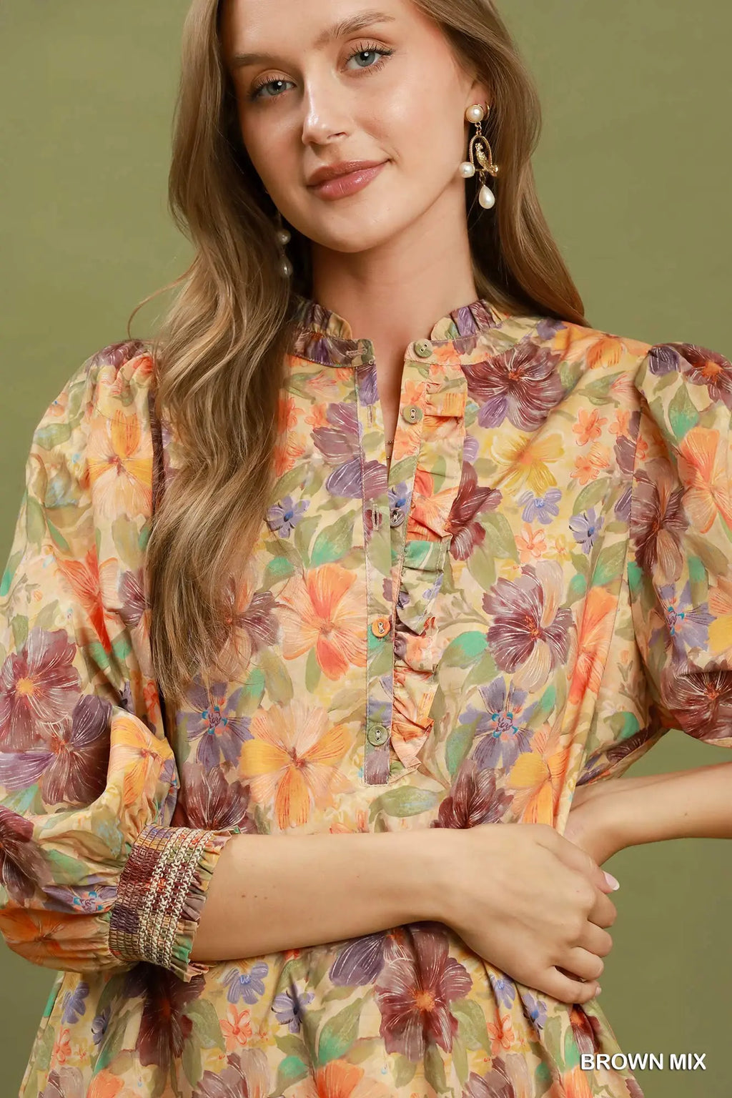 Woman wearing a colorful floral dress with a brown background