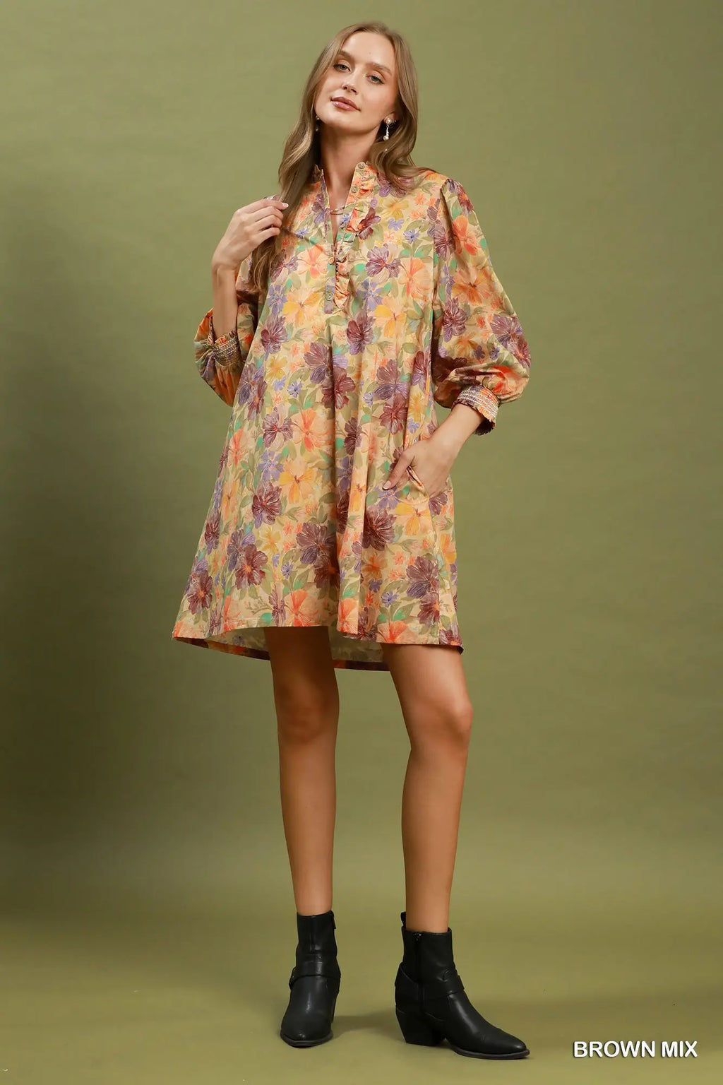 Woman wearing a floral dress with long sleeves on a green background