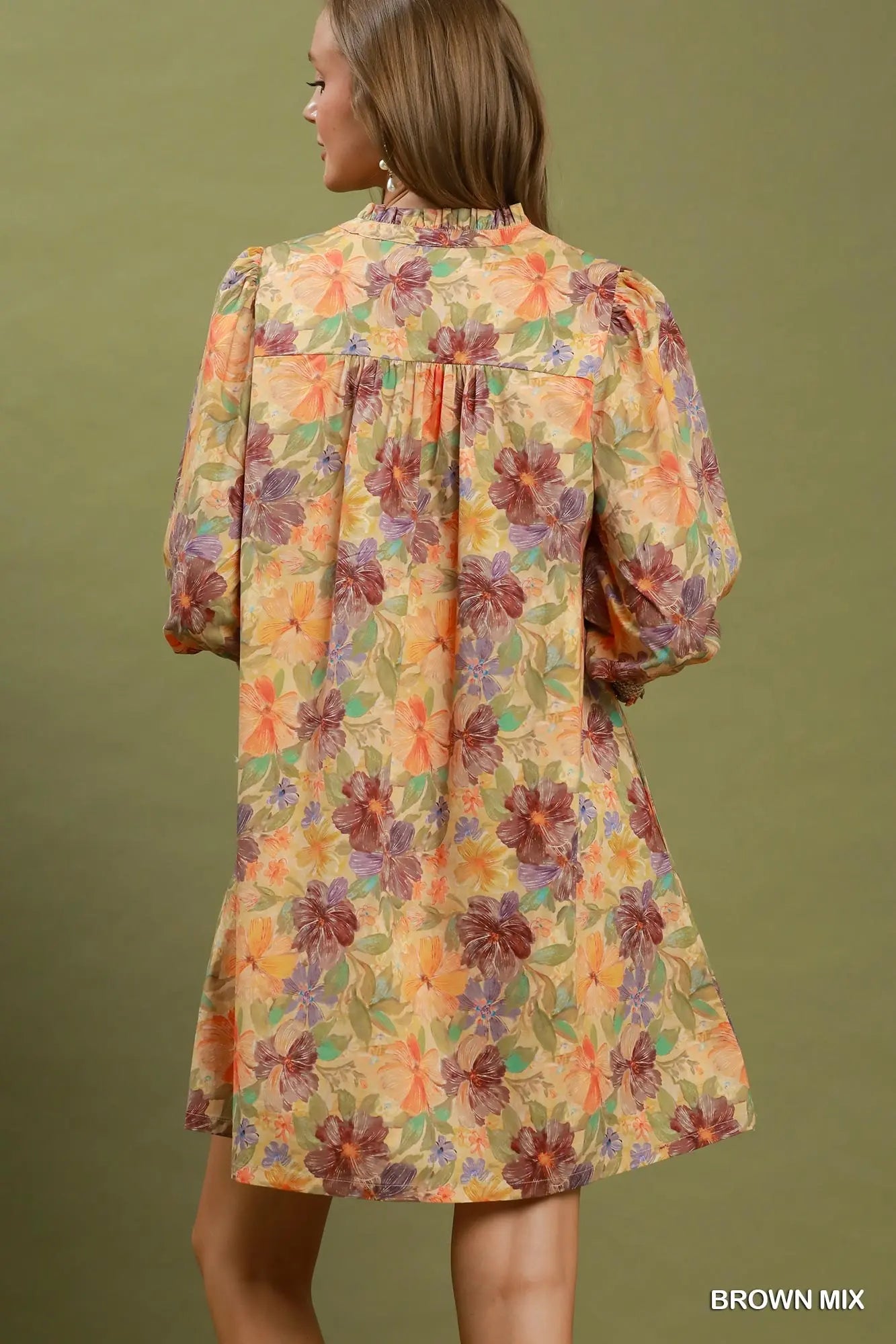 Woman wearing a floral dress with a brown background