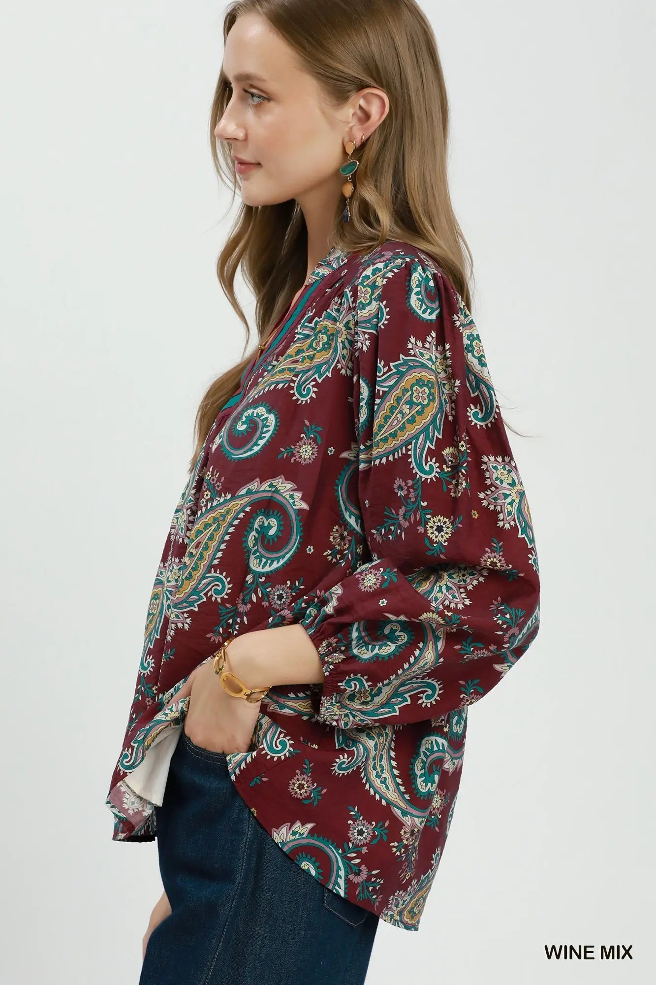 Woman wearing a wine mix patterned blouse on a white background