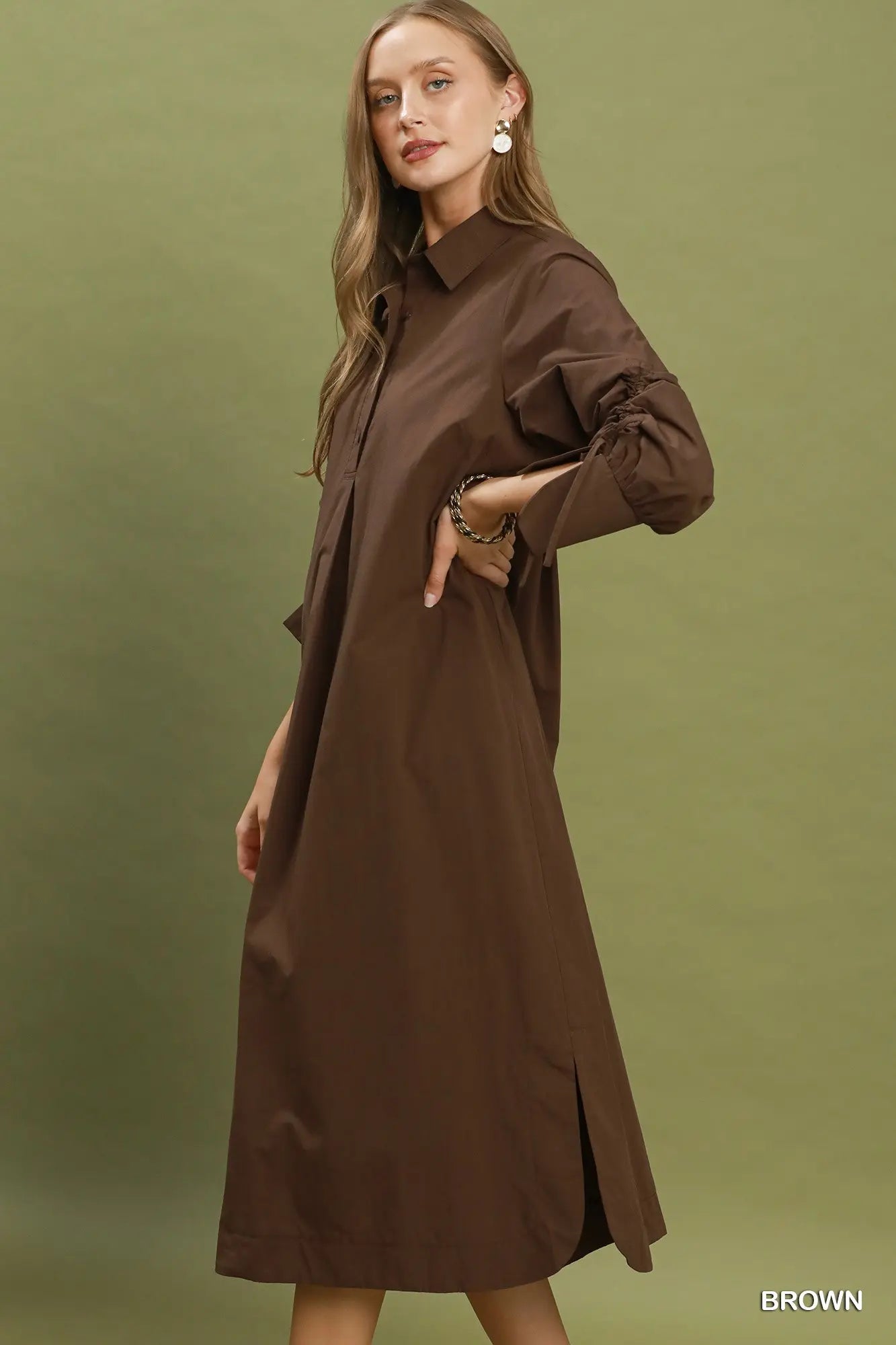 Woman wearing a brown dress against a green background