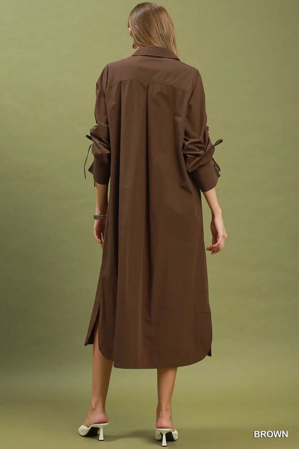 Woman wearing a brown dress against a green background