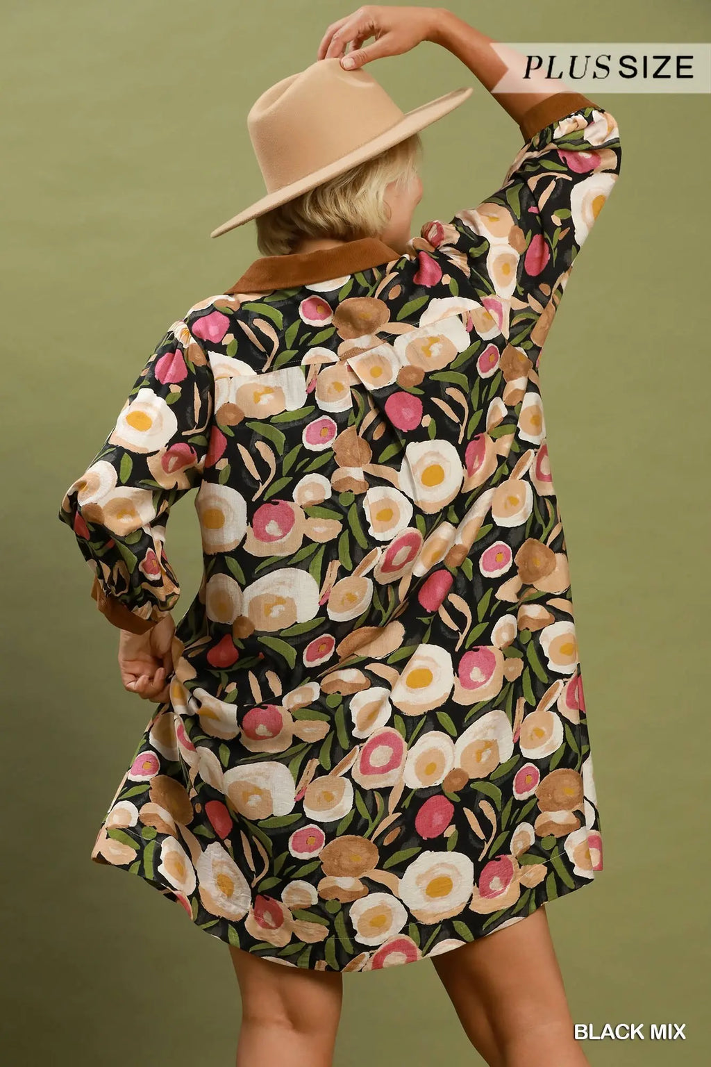 Woman wearing a floral dress with a beige hat against a green background