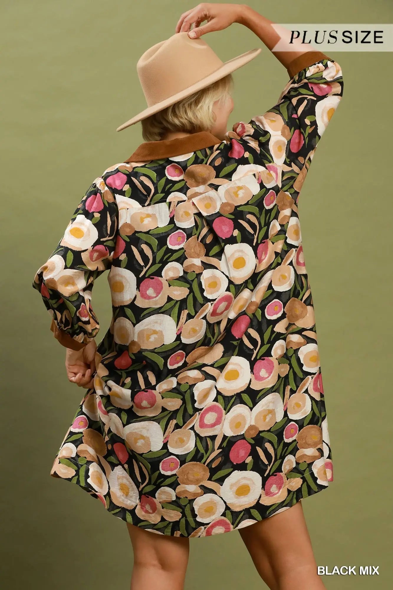 Woman wearing a floral dress with a beige hat against a green background
