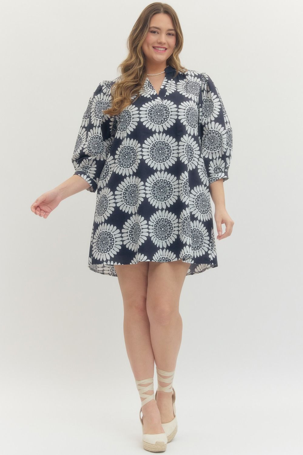 Woman wearing a navy and white patterned dress on a white background