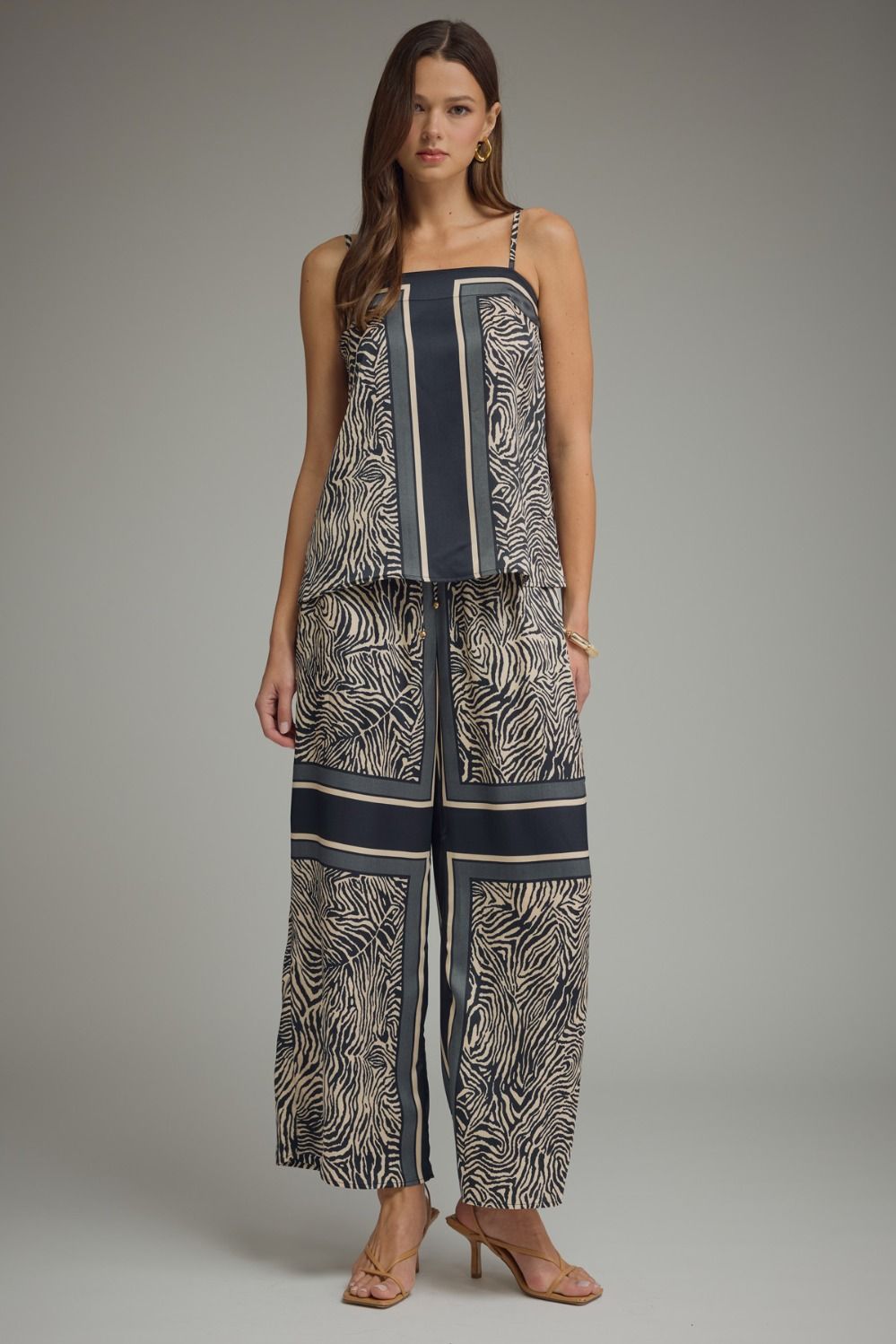 Woman wearing a patterned jumpsuit on a gray background
