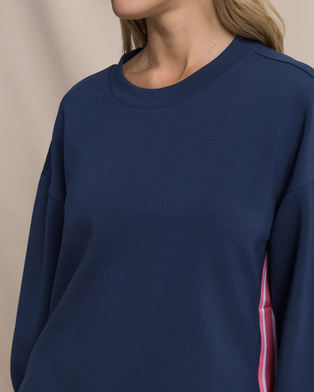 Navy blue sweatshirt with a red and white stripe on a beige background