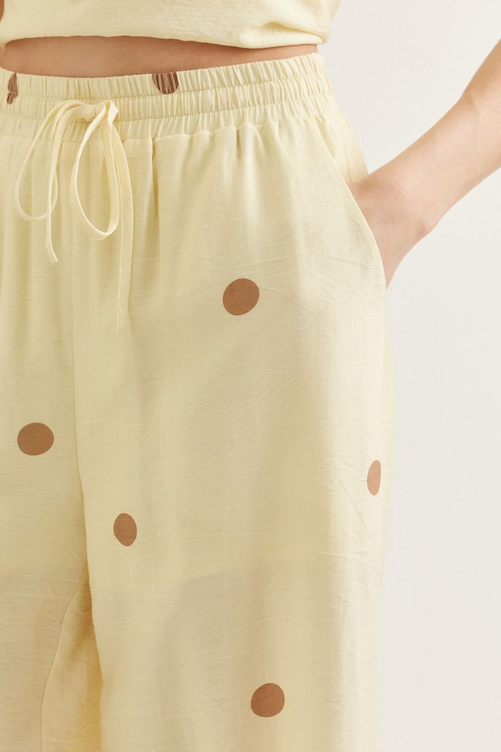 Yellow pants with brown polka dots on a white background
